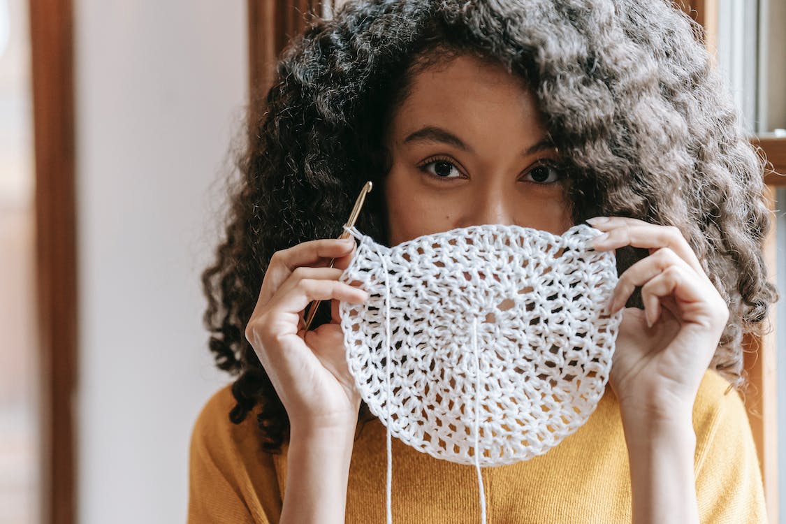 woman holding crochet coaster